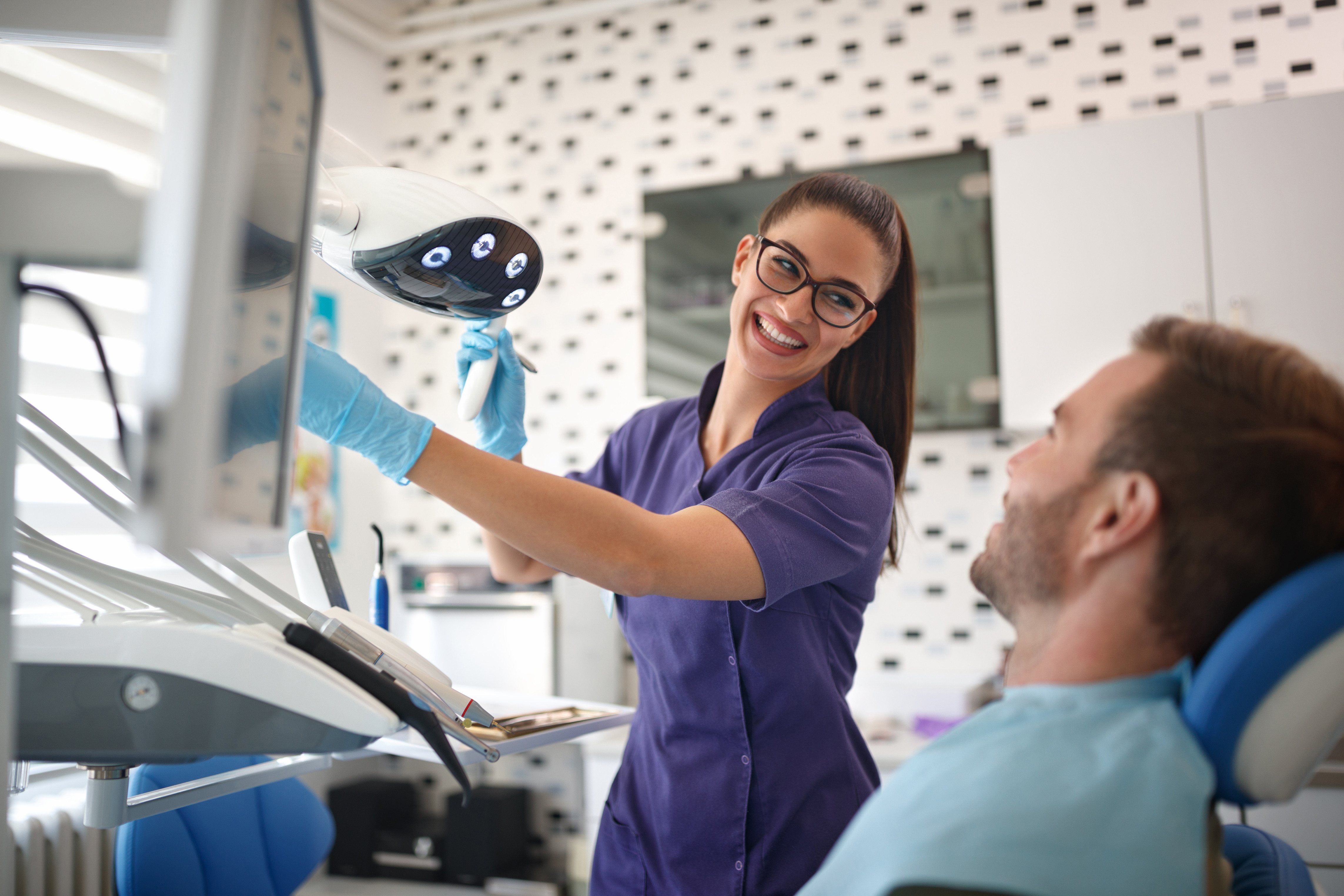 dental nurse and patient who is sat in a dentist chair