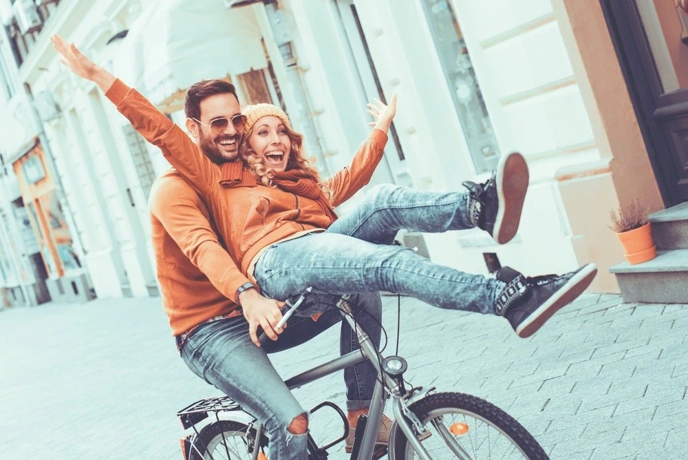 couple-smiling-riding-a-bike-together