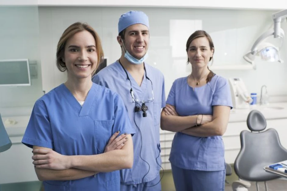  Three dentists stood in dental appointment room