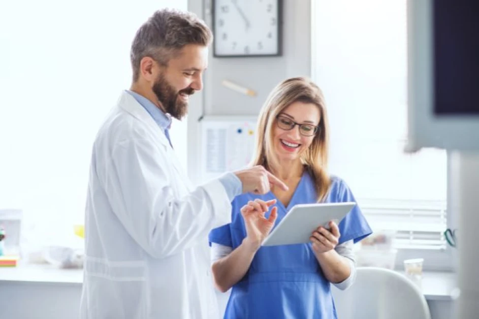  Dentist and nurse look and discussing positive results on a clipboard in a sterile dental room